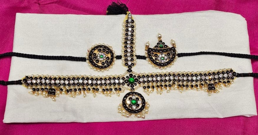 Close-up of Black Headset, intricate pure silver temple jewelry featuring traditional Surya and Chandra patterns.