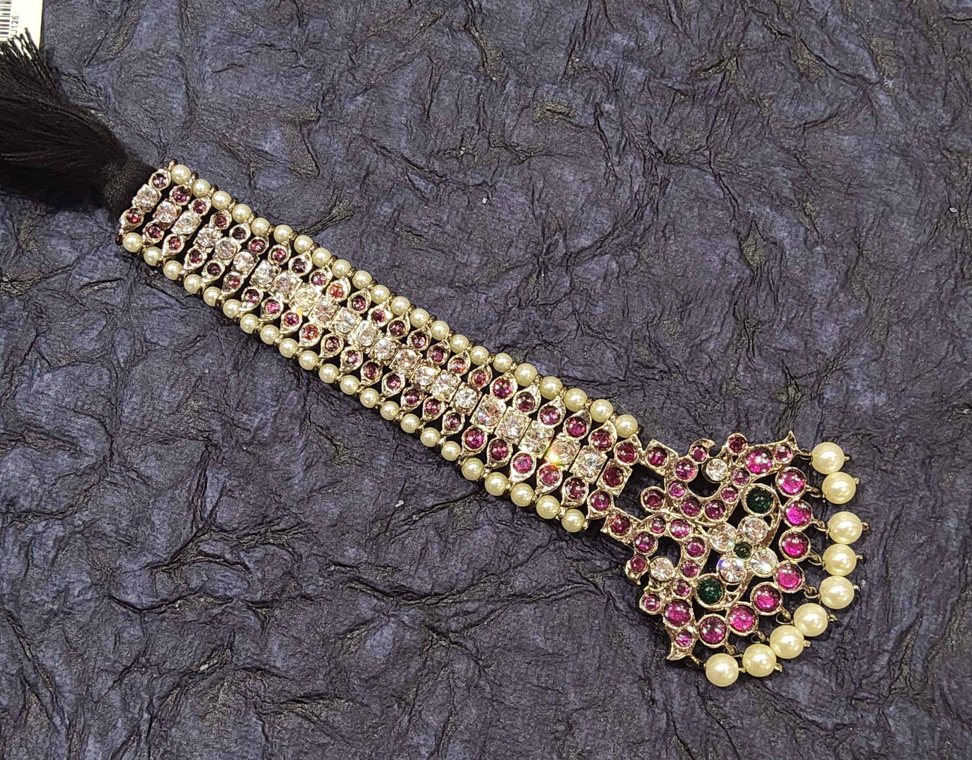 Close-up of Black Series Big Chutti Tikka: Copper temple jewellery detail with ruby stones.