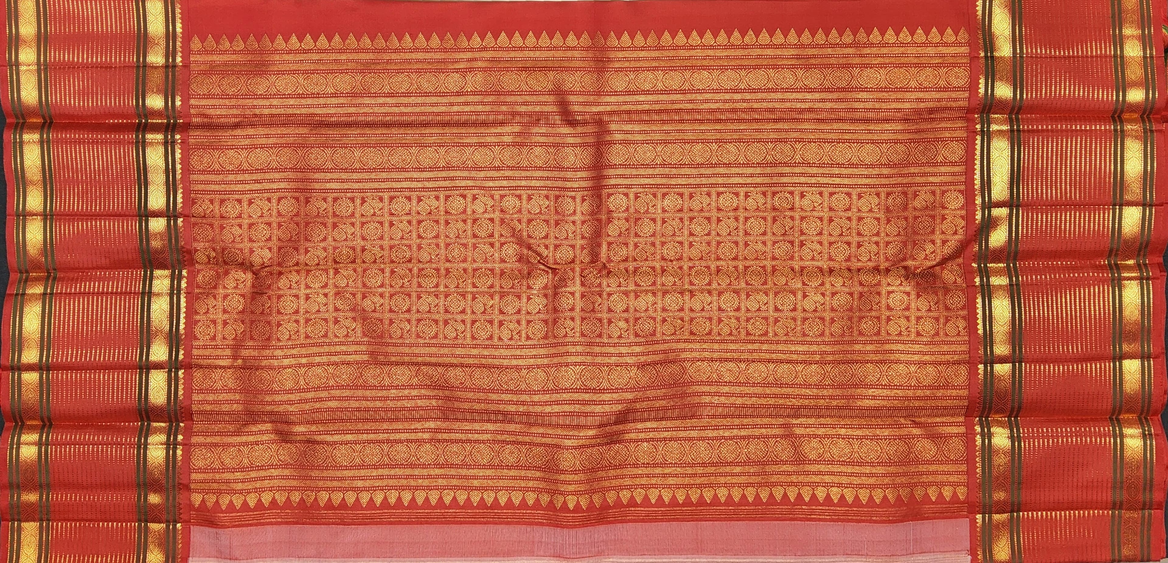 Close-up of red border and gold zari work on authentic silk Kanchipuram arangetram saree.