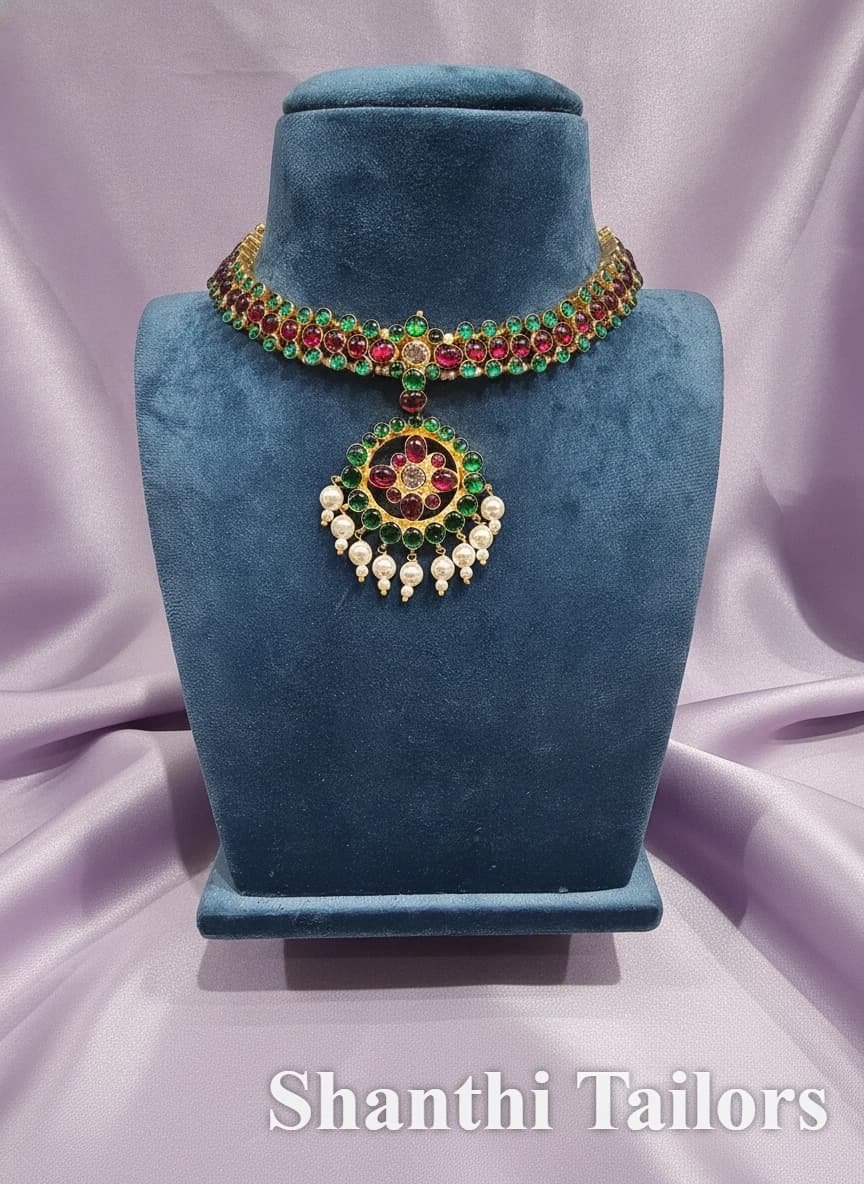 Original Temple Jewellery Palai Necklace: gold choker with red & green stones, pearl drops, on blue velvet display.