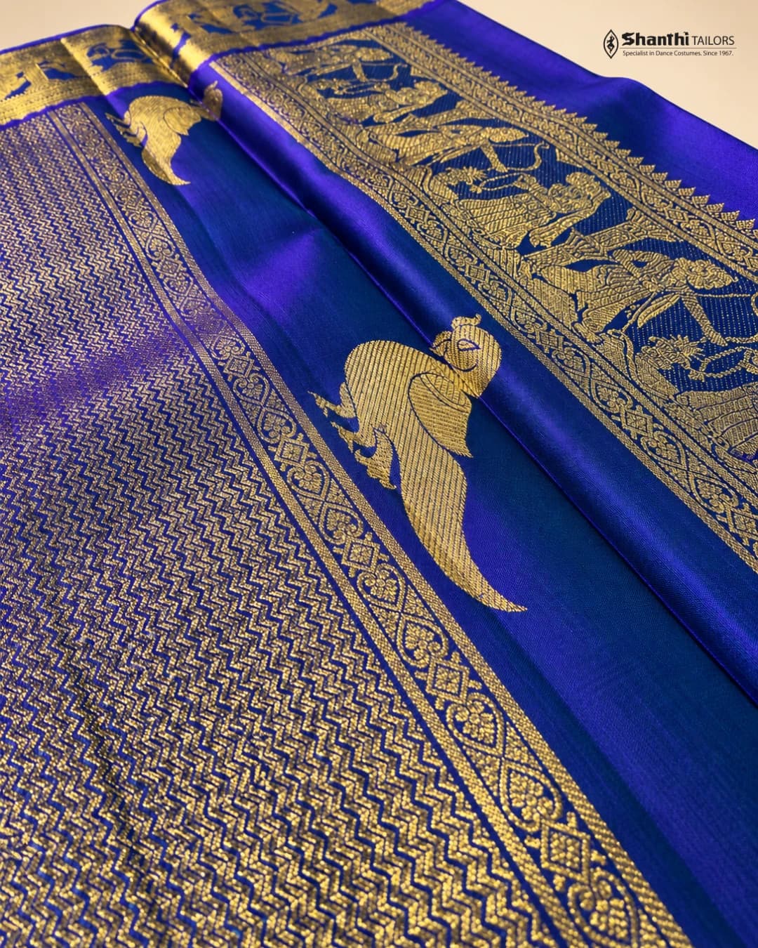 Pure Kanchipuram Silk Saree: vibrant royal blue with rich gold Zari border featuring intricate traditional motifs & body patterns.