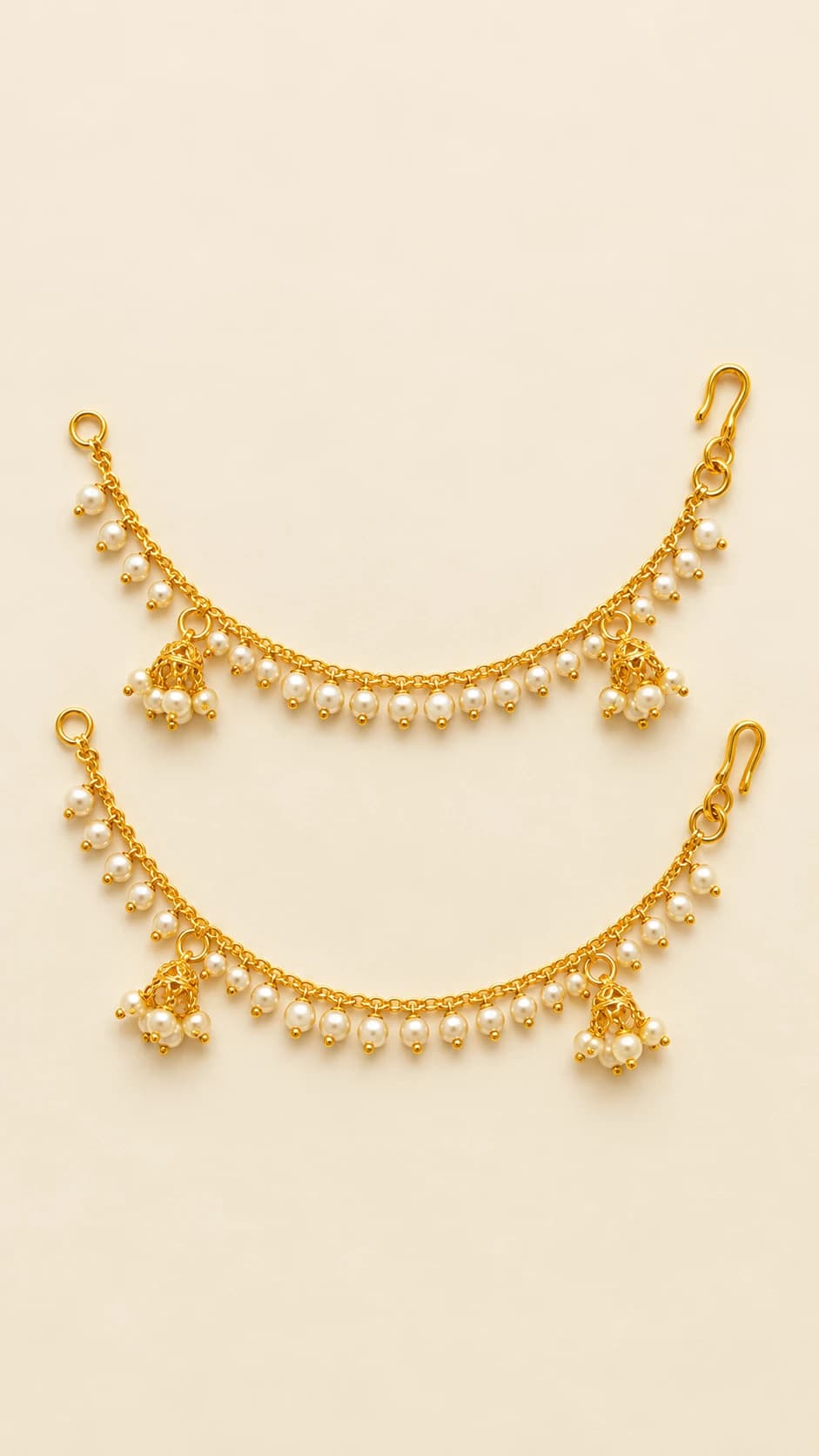 Pair of antique mattal ear chains in gold-tone with hanging pearls, elegant fashion jewellery.