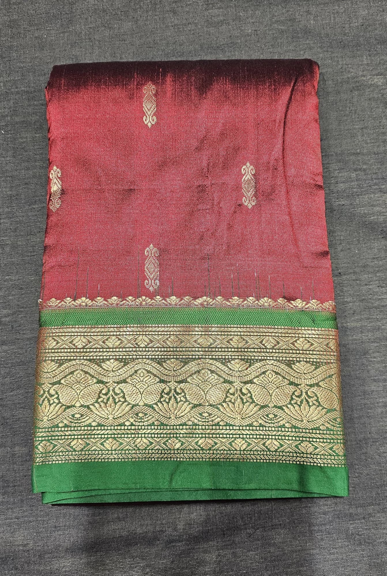 Maroon w Green Dharmavaram Silk Saree with gold zari motifs and intricate green border, folded.