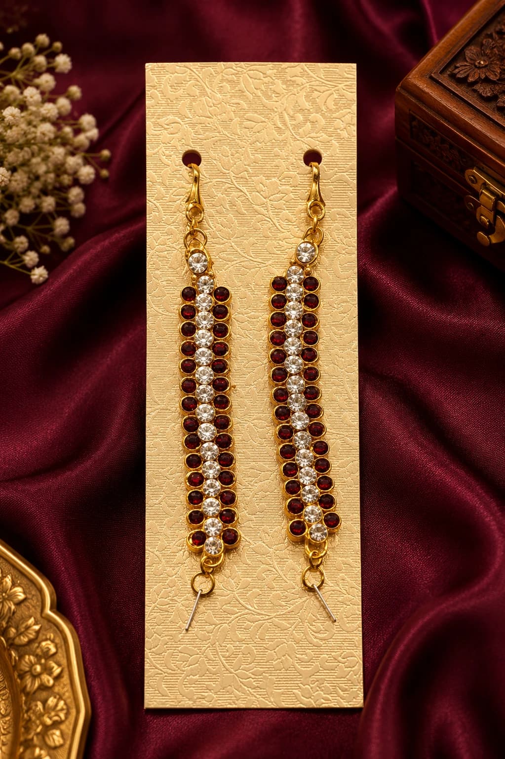 Pair of Kemp Mattal imitation jewellery with red & white stones, displayed on gold card & maroon satin.