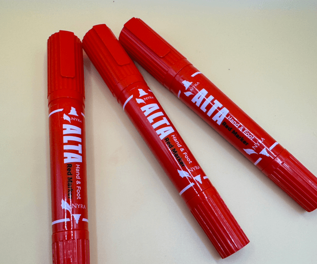 Close-up of a dancer's foot with vibrant red alta applied using the Nyra Alta Pen, showcasing precision.