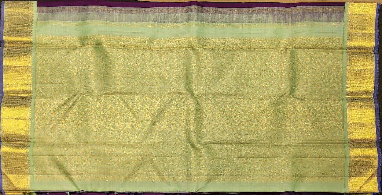 Close-up of purple Kanchipuram authentic silk saree with gold zari border and pista pallu.