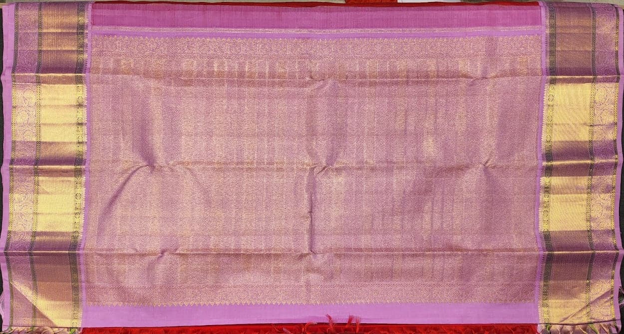 Close-up of gold zari work on authentic silk Kanchipuram saree border.
