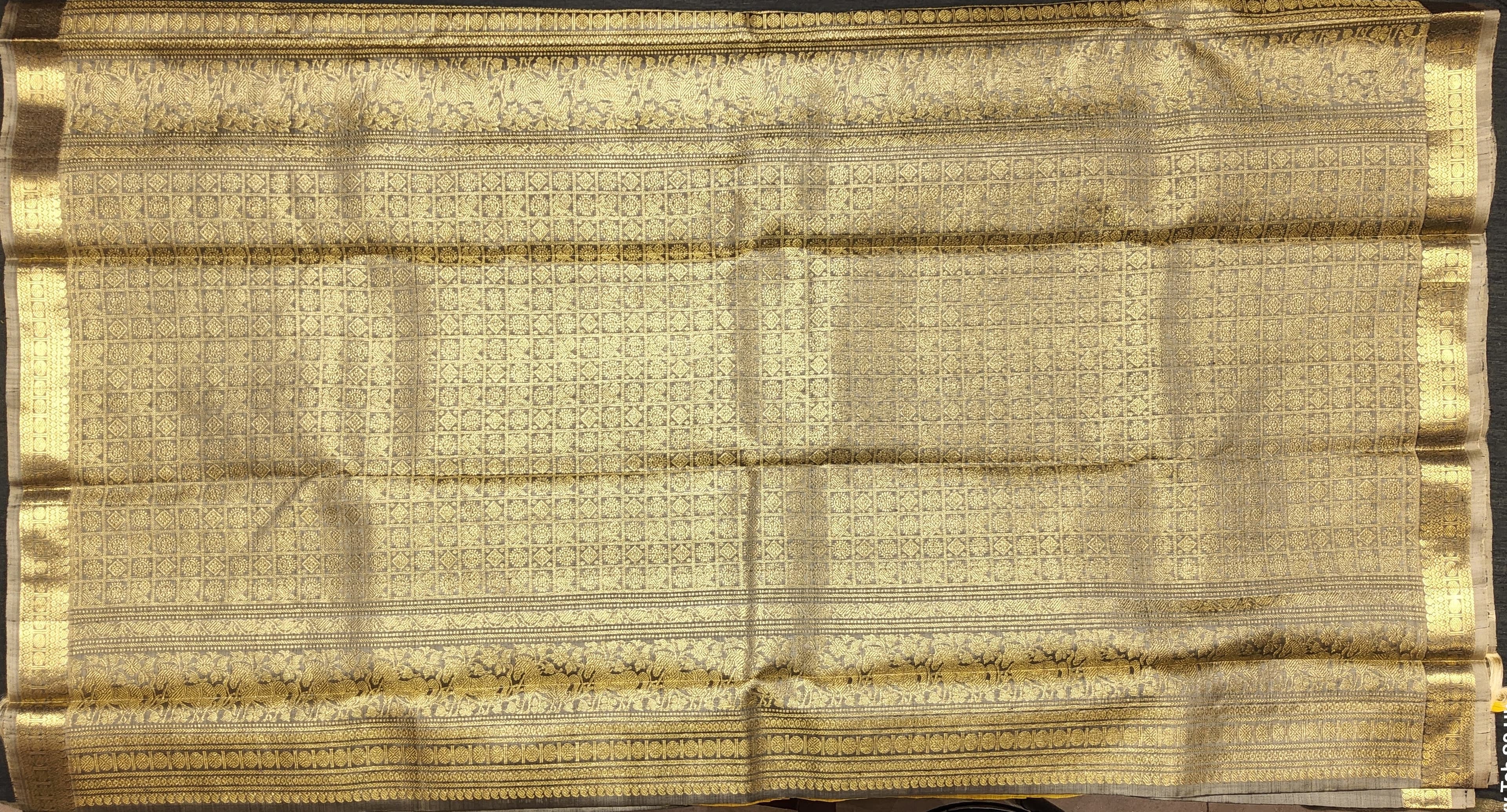 Close-up of Kanchipuram authentic silk saree border; gold zari detailing for Arangetram.
