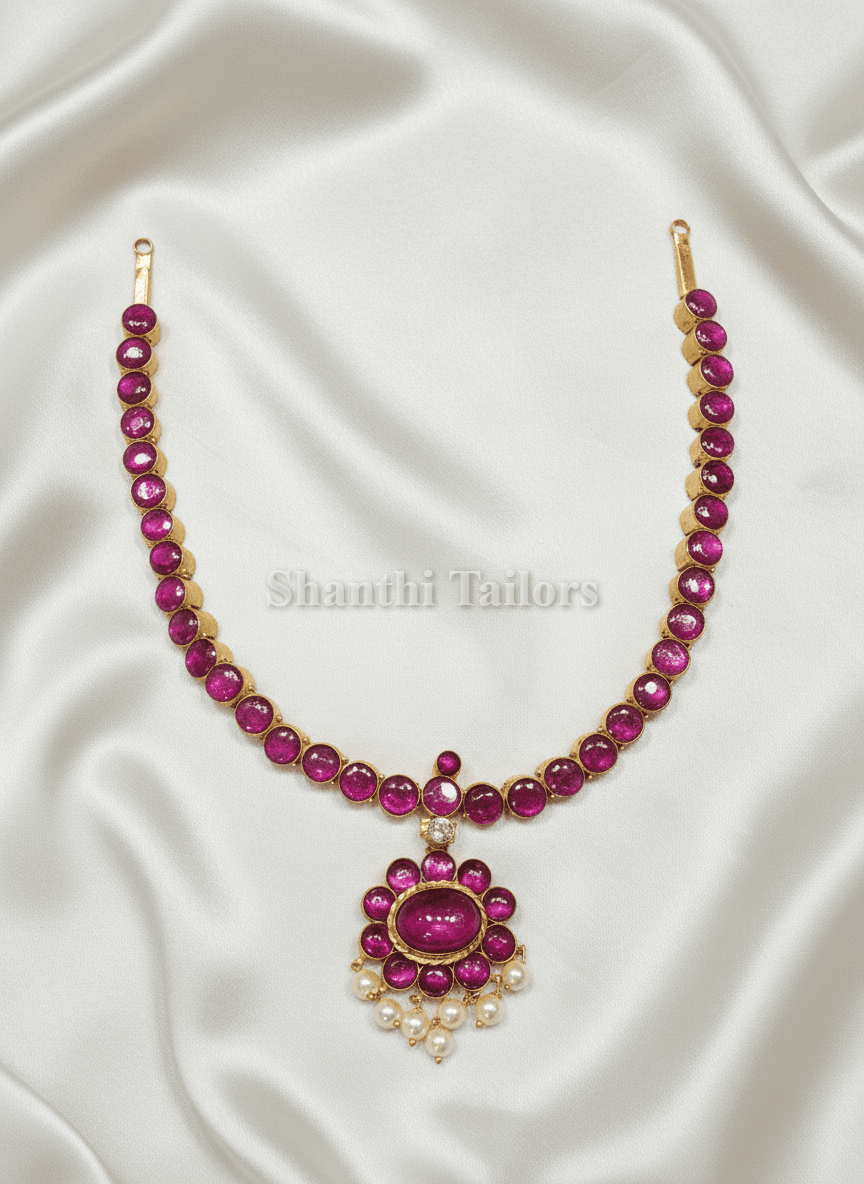 Close-up: Attigai Temple Jewellery necklace with single stone, silver base gold leaf, kemp stone