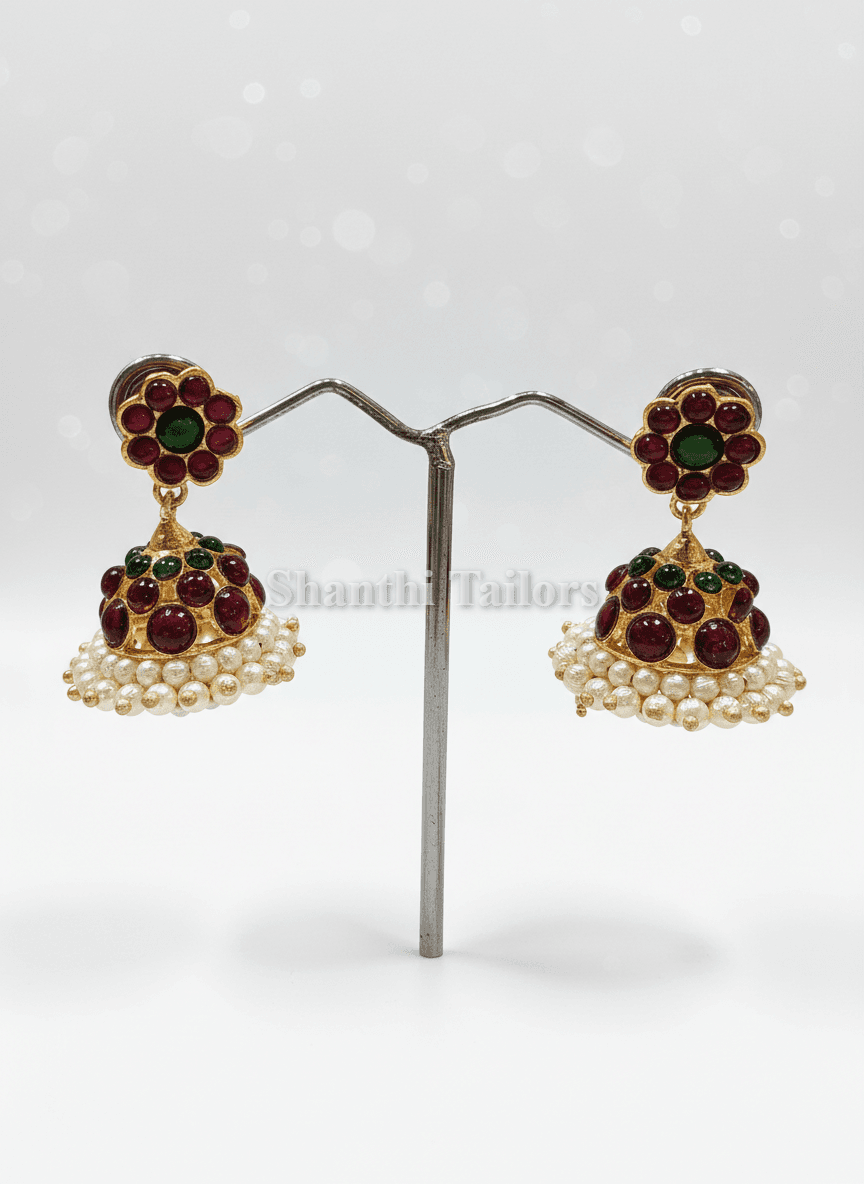 Close-up of small kemp stone jummiki earrings, silver base gold leaf, bharatanatyam jewellery.