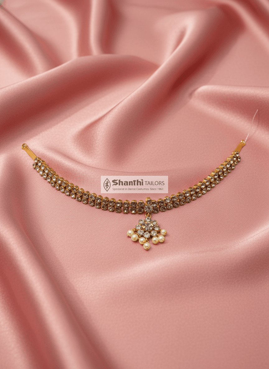 Close-up: silver base gold leaf 2-Stone Attigai, Red Kemp, temple jewellery. Bharatanatyam costume detail.